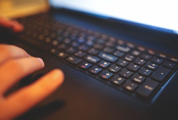 Person typing on a laptop keyboard creating their digital marketing