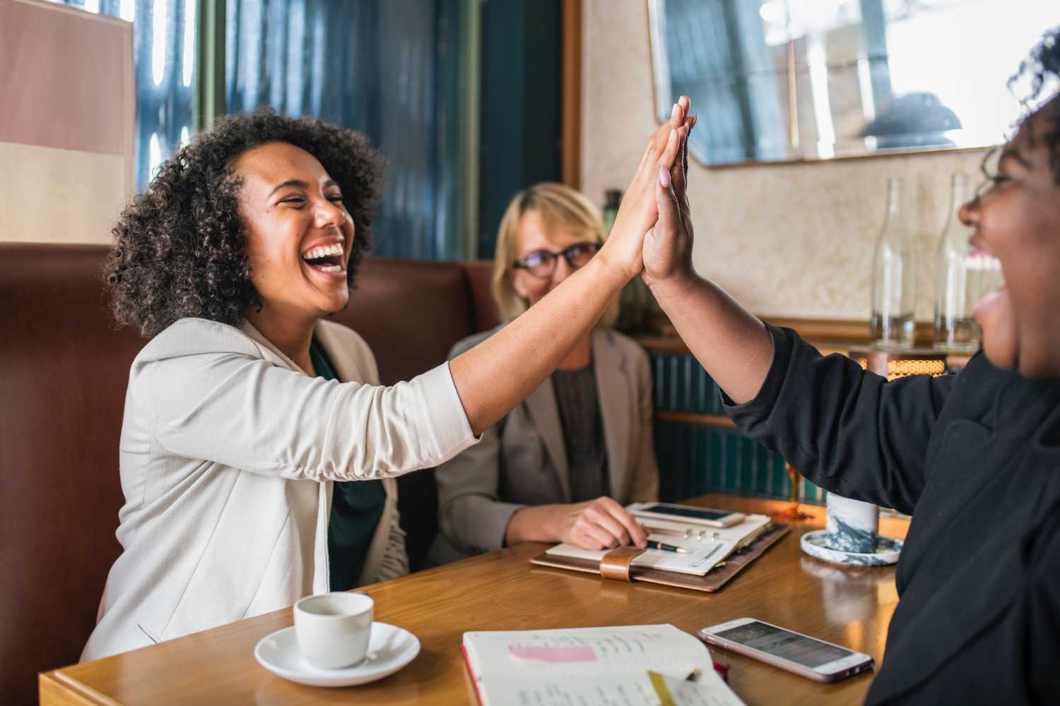 Happy women giving each other a high five after reviving their sales